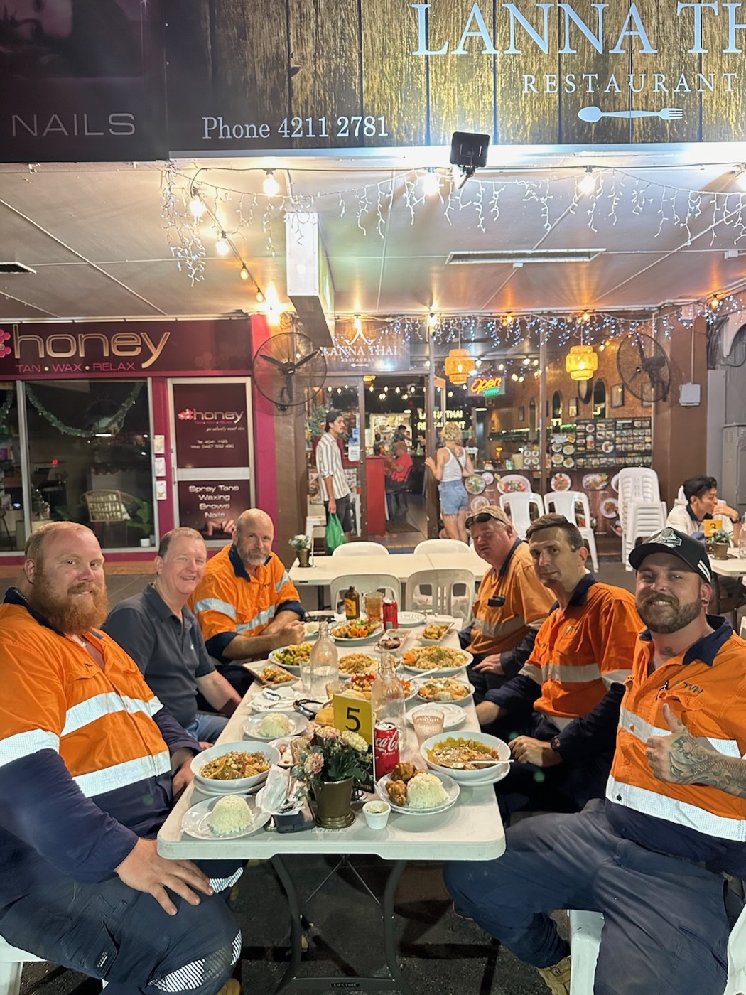 The crew in hi-vis sharing a meal around a table after a hard day's work