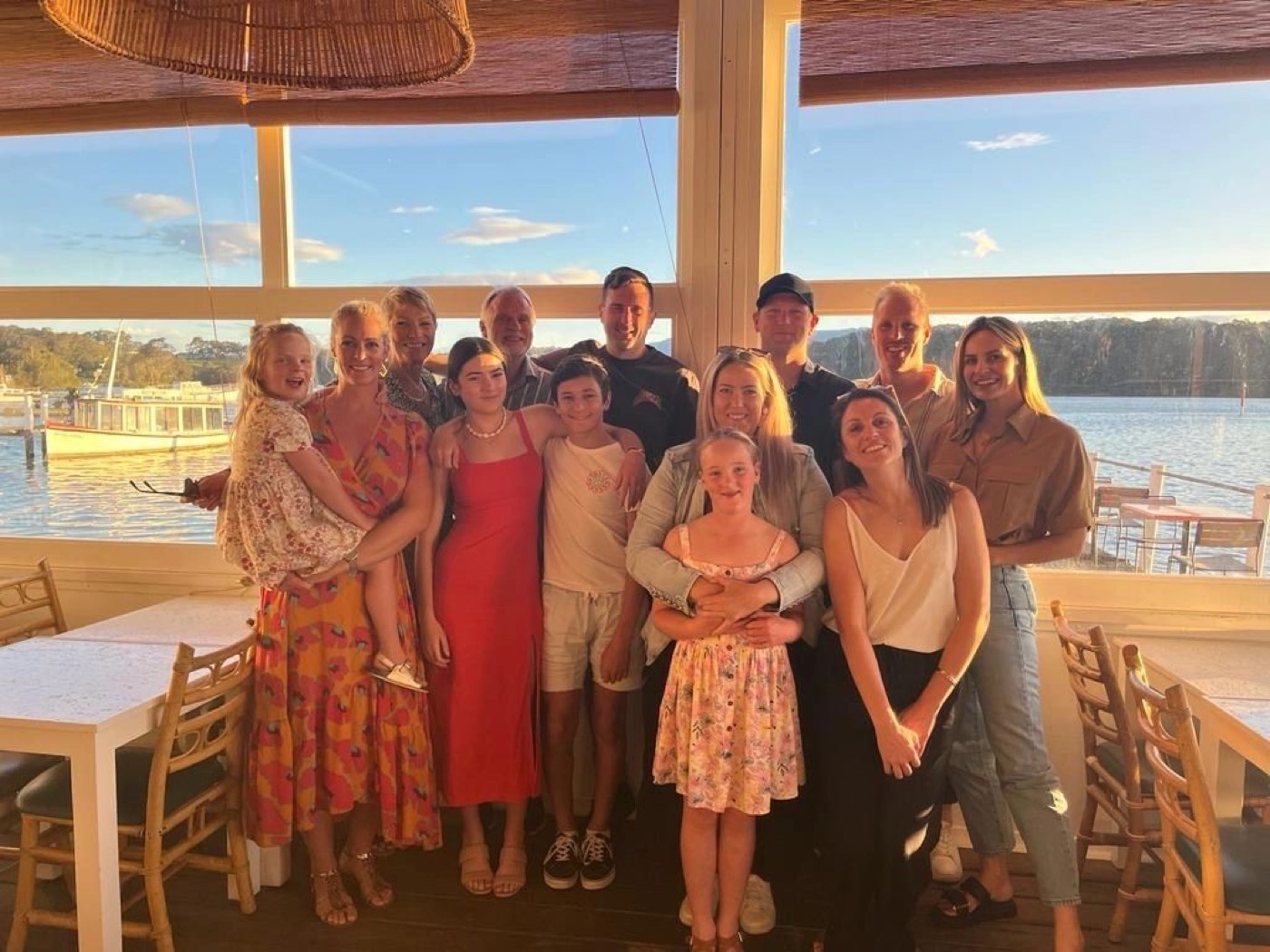 JL with his family at a waterfront restaurant at sunset