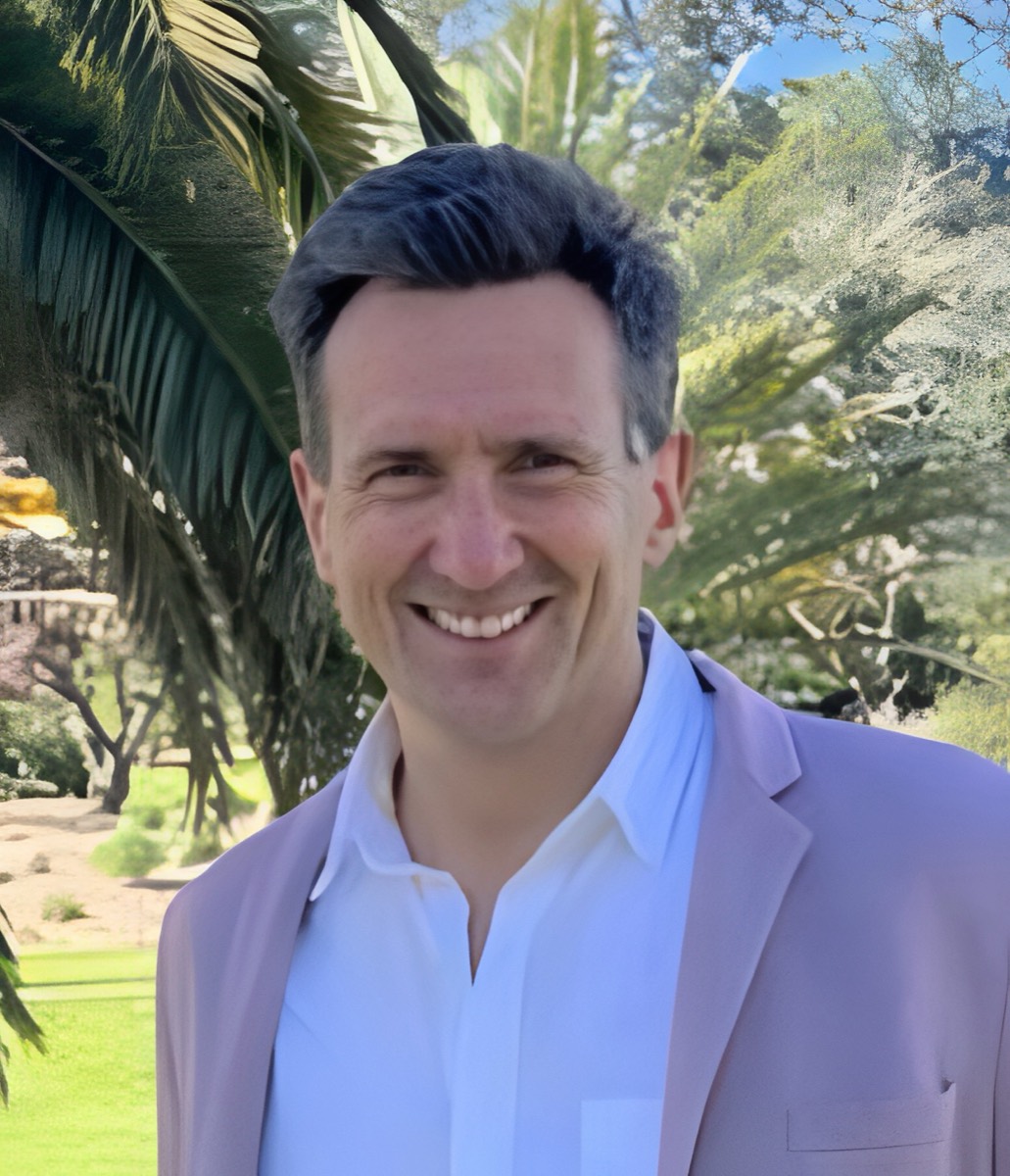 Joshua Leys smiling, wearing a pale pink blazer and white shirt