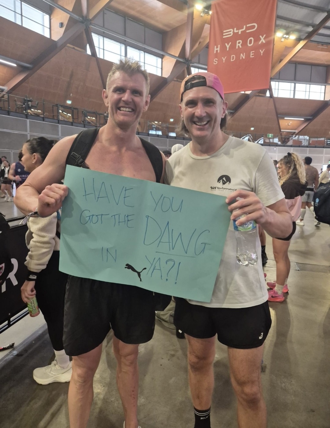 JL and a mate at HYROX Sydney holding a sign that reads: Have you got the dawg in ya?